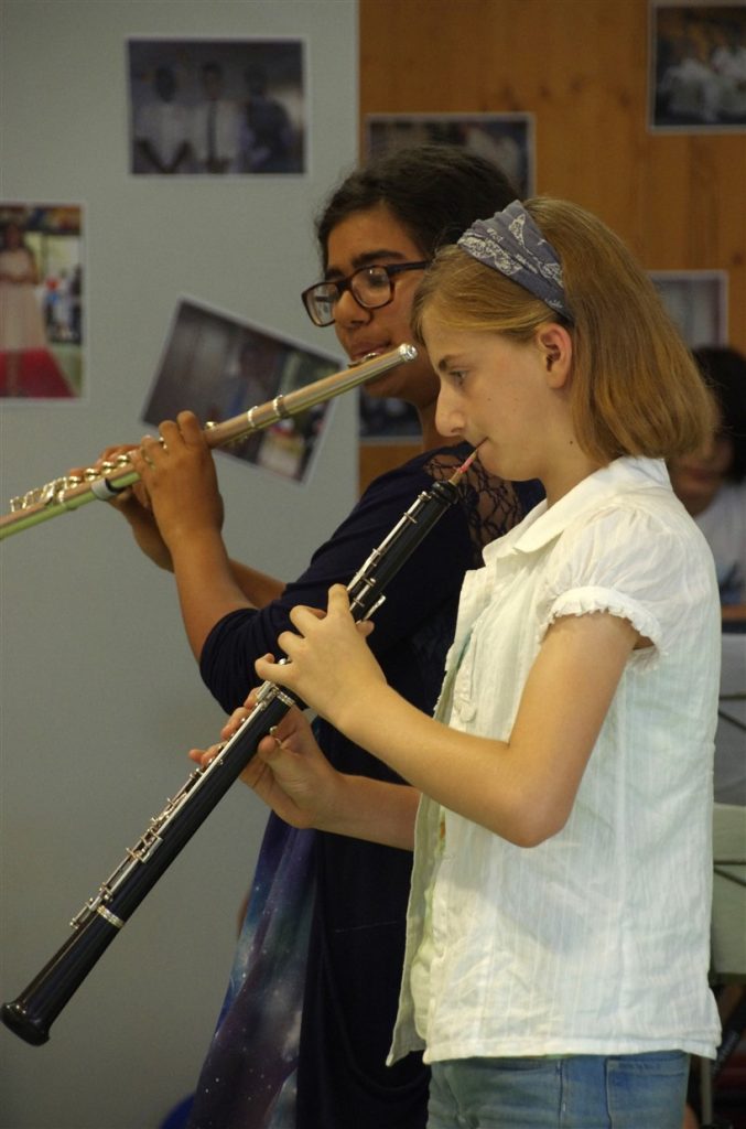 Two students playing a duet on flute and oboe.